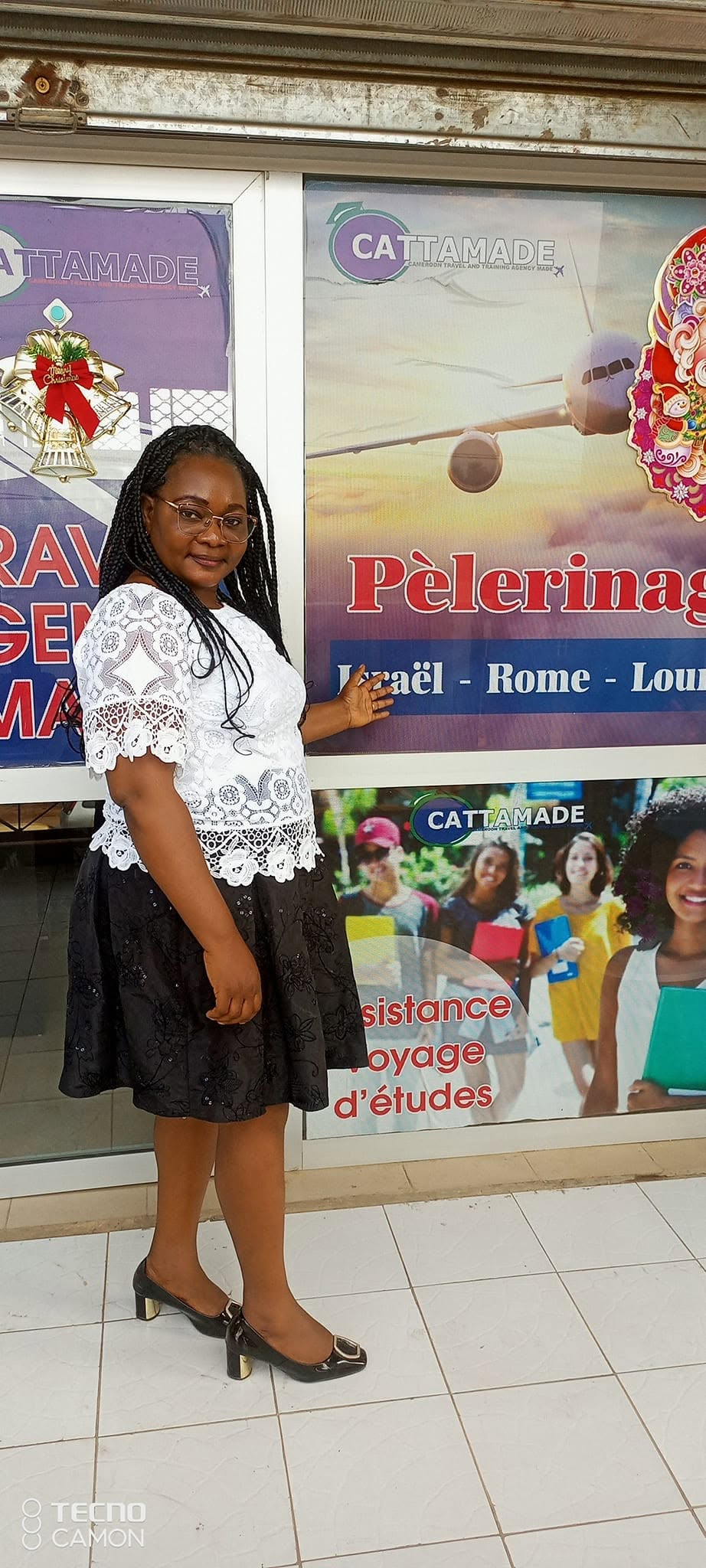 La directrice devant l’agence Cattamade et ses offres de voyages